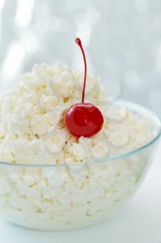 Cottage cheese in a transparent  bowl with cherry