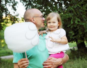 man holds his daughter and cotton candy