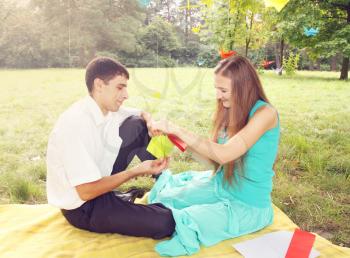 man and woman relaxing on nature make origami