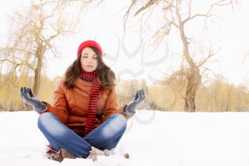 Young girl in lotus pose in the snow