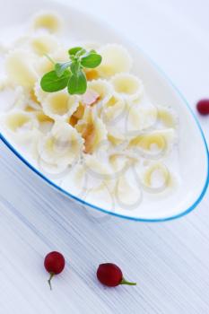 Pasta with milk and berry jam on the table