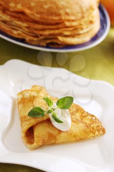 Pancake with sour cream on the plate