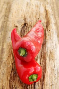 Ripe red peppers on old wooden board