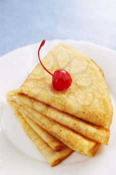 pile pancakes with cherries on a plate