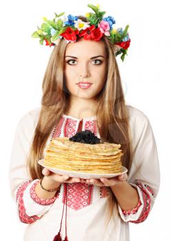 Ukrainian woman in a wreath holds pancakes with caviar