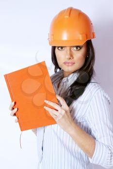 The woman in the construction helmet with a notebook in hand