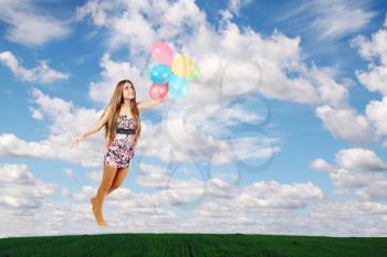 woman flies on the balloons in the clouds