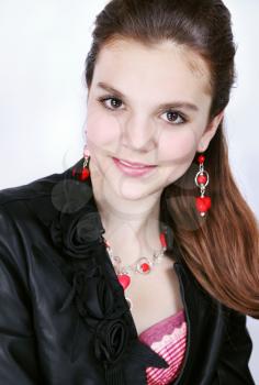 Portrait of a young girl in earrings and a necklace of coral