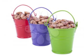 Multicoloured buckets with beans on a white background.