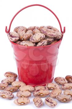 Red pail with beans on a white background.