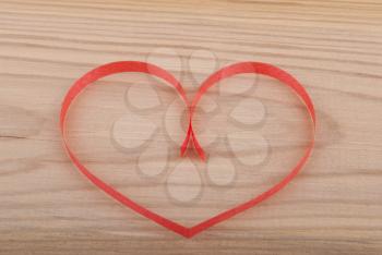 Heart from paper on wooden background.