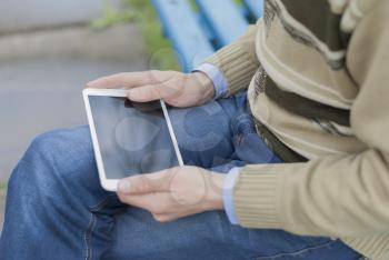 Man with tablet in park.