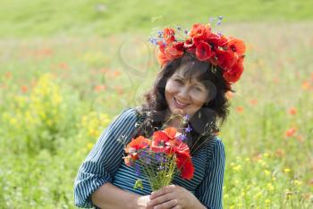 Woman in a field with poppy flowers.