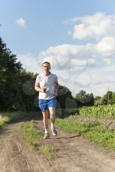 Sportsman running on the open countryside.