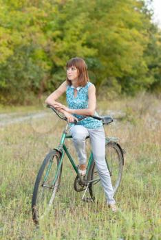 Beautiful girl with an old bicycle.