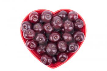 Cherries on a plate in the shape of a heart on a white background.