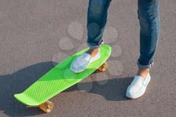 Teenager in jeans with a skateboard in the street.