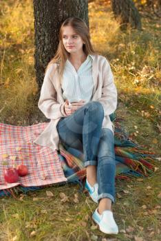 Young woman resting in a park in autumn.