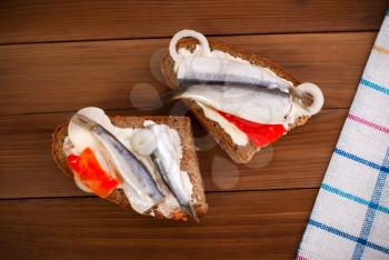 Sandwiches with herring on wooden table. Top view .