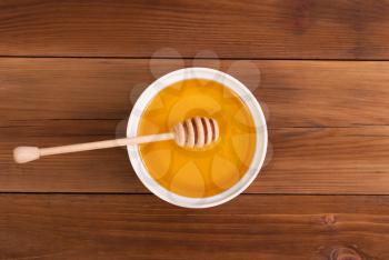 Honey in the jar with a spoon on a wooden table. Top view .