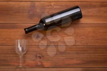 Bottle of wine and glass wine glass on a wooden background. View from above .