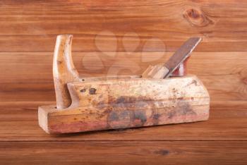 Old jointer on a wooden background.