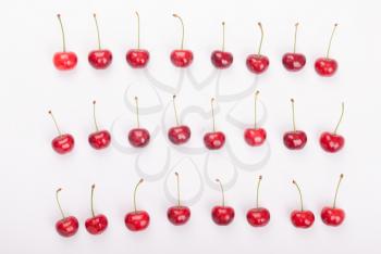 Red cherries lie on a white background.