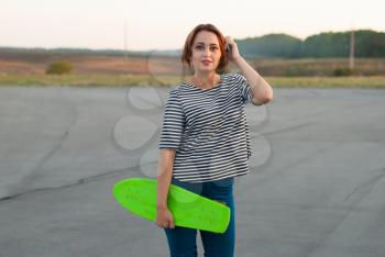 Girl with skateboard on the street.