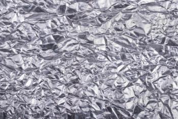 Silver crumpled foil texture background.