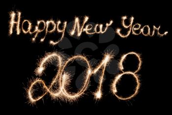 Happy New Year 2018 sparklers inscription on a dark background.