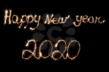 Happy New Year 2020 inscription with sparklers on a black background.