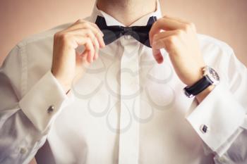 Closeup Of Business Man Adjusting Neck Bow Over Brown Background