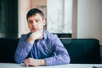 Handsome Thinking Man In Blue Shirt Sitting In Cafe