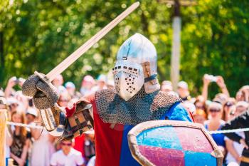 Historical Restoration Of Knightly Fights. Summer Time. Knight In A Fight With Sword