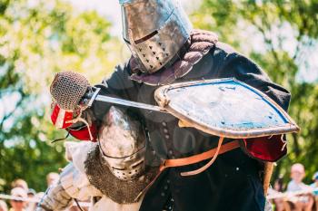 Historical Restoration Of Knightly Fights. Summer Time. Knights In A Fight With Sword