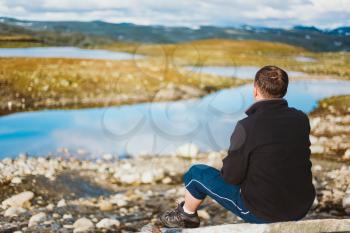 Man Sitting On Stone In Norway Mountains