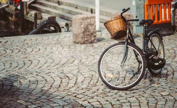 Vintage Bicycle With Basket Parked On Sidewalk. Bike Parking In Big City. Toned Instant Photo