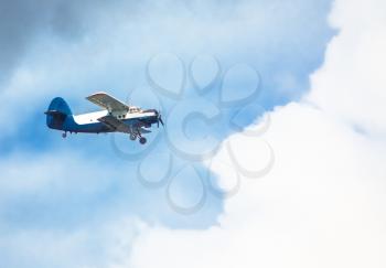 Biplane In Blue Sky Over Clouds