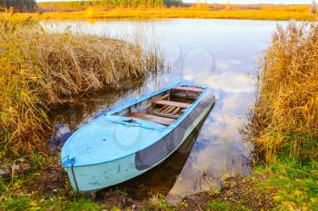 Autumn River And Blue Rowing Boat On Yellow Grass
