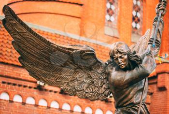 Statue of Archangel Michael with outstretched wings, thrusting spear into dragon before Catholic Church of St. Simon and St. Helena on Independence Square in Minsk, Belarus