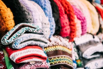 Close View Of Various Colorful Traditional European Warm Clothes - Caps, Hats At Winter Christmas Market. Souvenir From Europe.