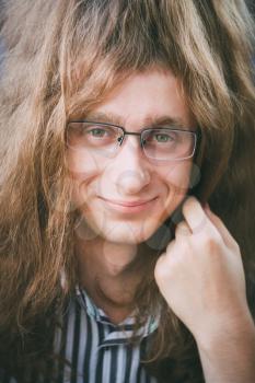 Portrait Of Hippie Hippy Young Man Guy With Glasses And Long Hair Smiling And Looking At Camera
