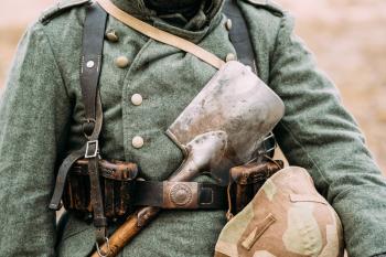 Close up of German military ammunition of a German soldier At World War II. Warm autumn clothes, soldier's overcoat, gloves, helmet, pouch, sapper shovel.