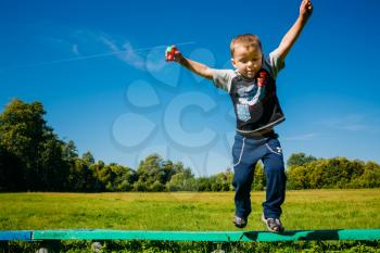 Little Boy Jumping From Bench Summer Sky Background