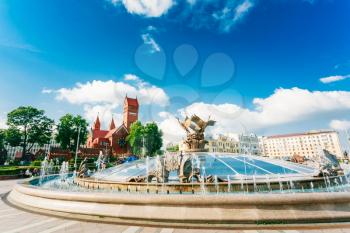 Fountain At Independence Square And Church Of Saints Simon And Helen (Red Church) In Minsk, Belarus