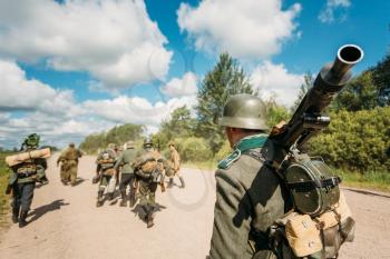 Unidentified re-enactors dressed as German soldiers 
during march through summer forest