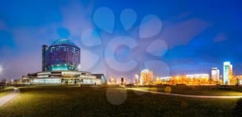 Minsk, Belarus. National Library Building In Evening LED Illumination On Blue Sky Background. Famous Hi-Tech Modern Landmark, Cultural Informational Science Center. Night Panorama