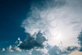 Blue sky background with sun and white fluffy clouds. Weather concept