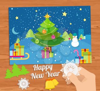 Hand with snowflake and New Year greeting card with decorated christmas tree, snowmans and gifts against the background of glowing windows of a night city
