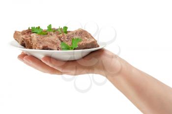 hand holds a dish with meat